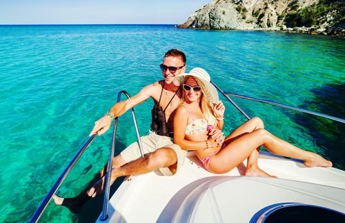 Couple Smiling on a Yacht over Clear, Blue-Green Water